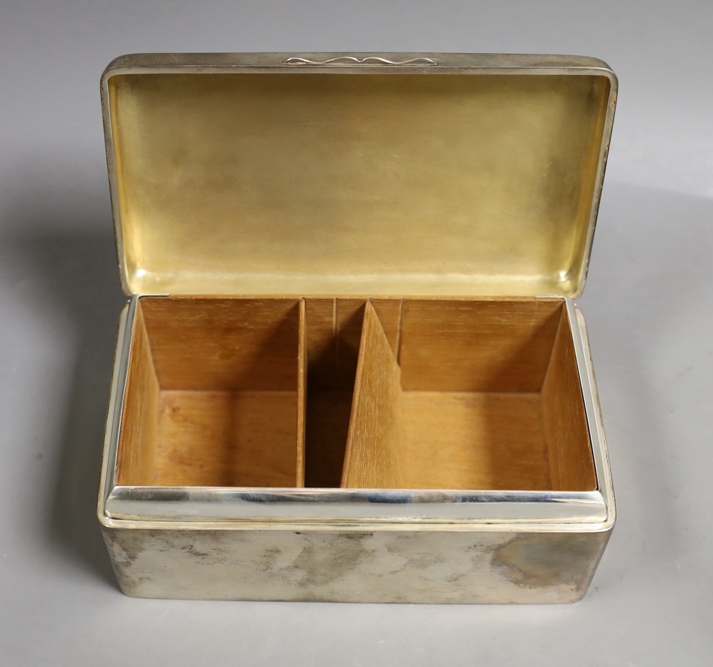 A George V silver mounted rectangular cigarette box, Birmingham, 1911, 17.2cm and an engraved white metal small tray.